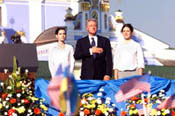The President, accompanied by Ukrainian students Kateryna Yasko, left, and Natalia Voinorovska, listens to our national anthem as part of the festivities at St. Michael's Square.